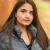 Close-up portrait of a young beautiful confident Indian Asian woman in fall outdoor. Happy and natural smiling female. Generation z and gen z youth